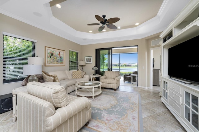 living room with ceiling fan, light tile patterned floors, a raised ceiling, and ornamental molding