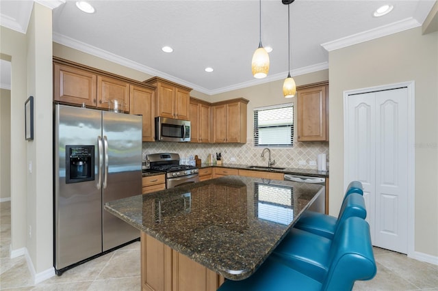 kitchen with dark stone countertops, stainless steel appliances, a kitchen breakfast bar, a kitchen island, and sink