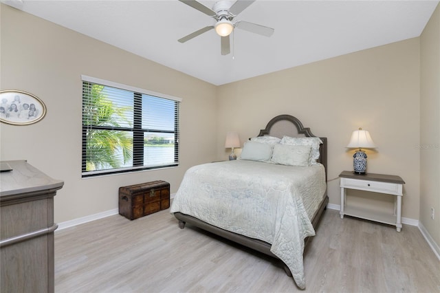 bedroom with ceiling fan, light wood finished floors, and baseboards