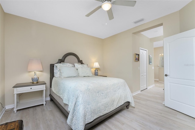 bedroom with ceiling fan, light wood-type flooring, visible vents, and baseboards