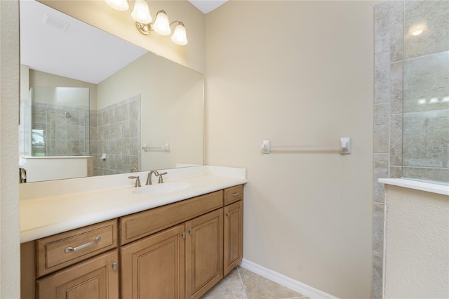 bathroom featuring tiled shower, vanity, and tile patterned flooring