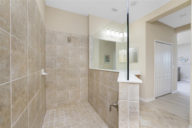 bathroom with hardwood / wood-style flooring and a tile shower