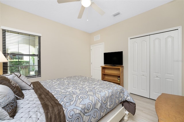 bedroom featuring light wood-type flooring, ceiling fan, and a closet