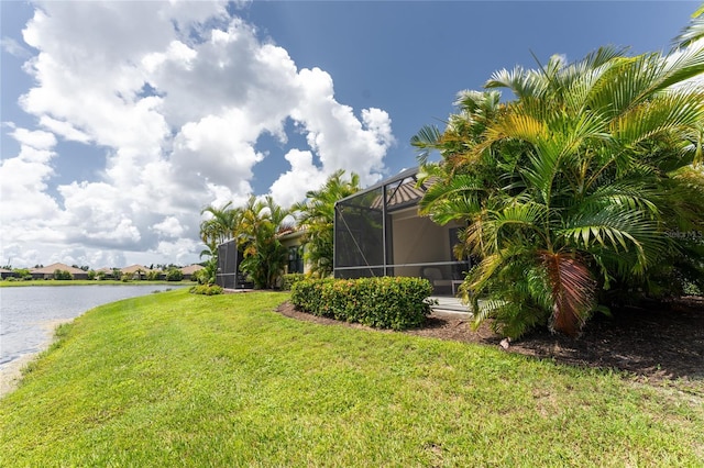 view of yard featuring a water view and glass enclosure