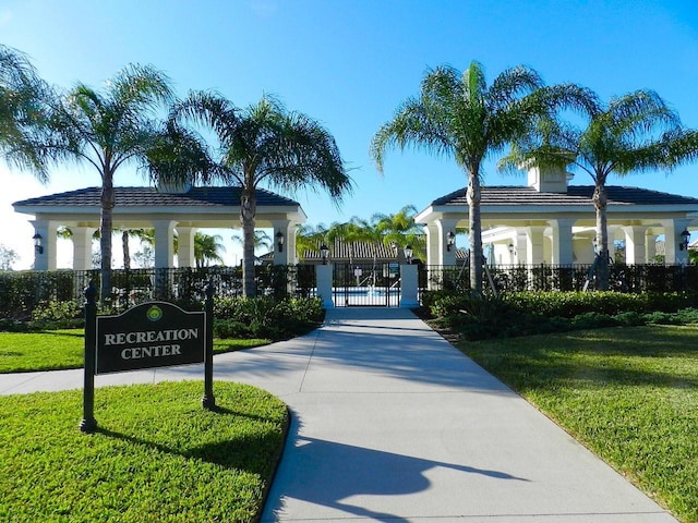 view of community with a gate, fence, and a lawn