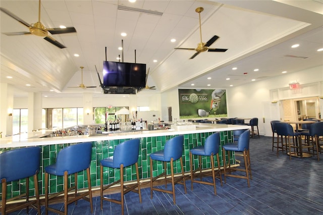 bar with a ceiling fan, lofted ceiling, a bar, and recessed lighting