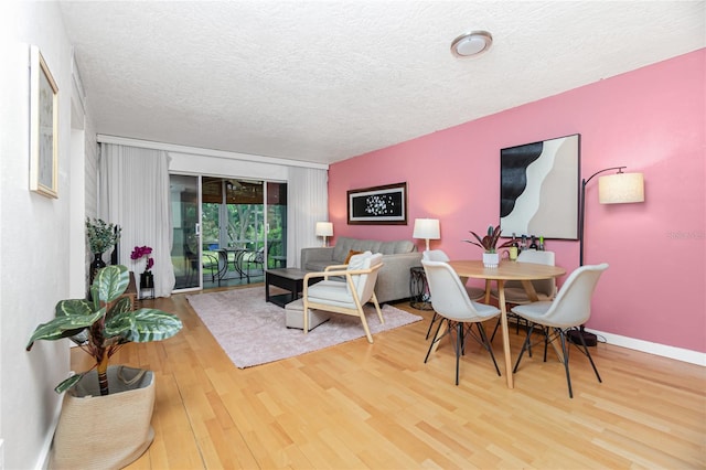 dining room featuring hardwood / wood-style floors and a textured ceiling