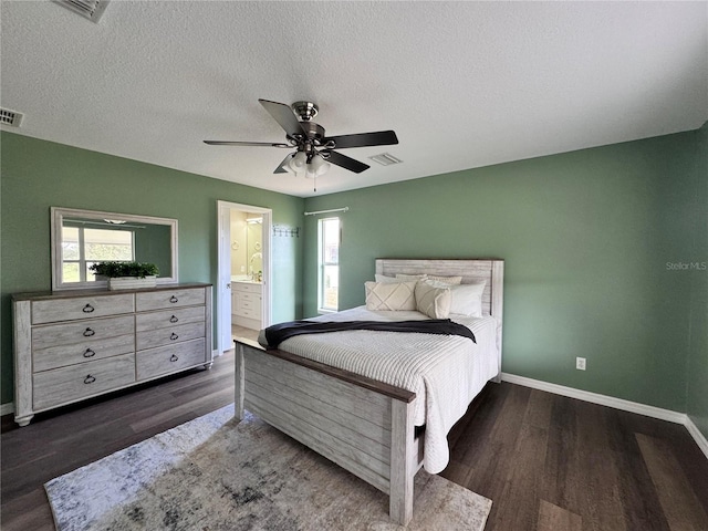 bedroom with multiple windows, dark hardwood / wood-style floors, connected bathroom, and ceiling fan