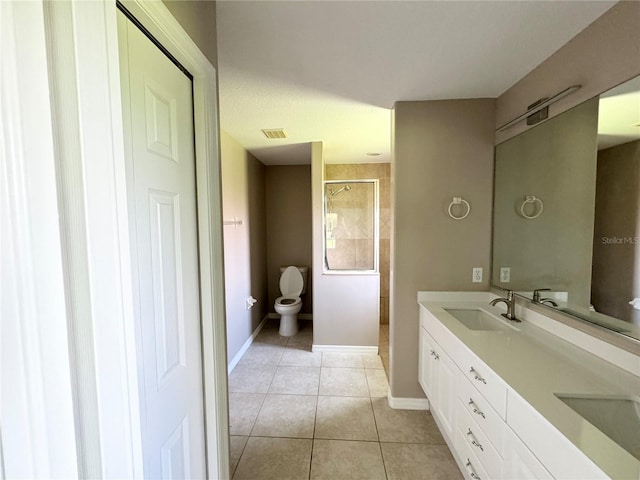 bathroom featuring tiled shower, tile patterned floors, toilet, and vanity