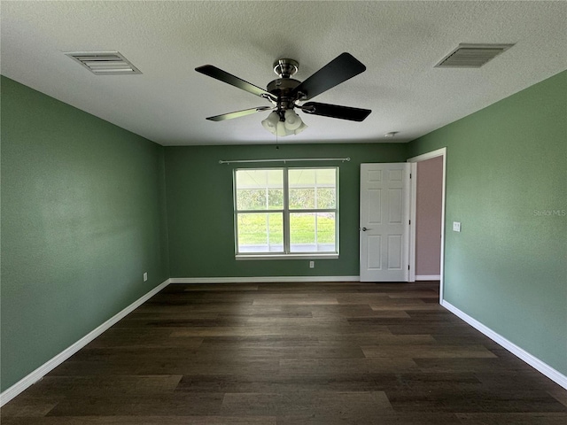 empty room with dark hardwood / wood-style flooring, a textured ceiling, and ceiling fan