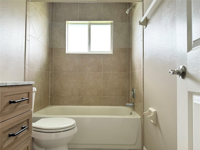 full bathroom featuring vanity, tiled shower / bath combo, and toilet