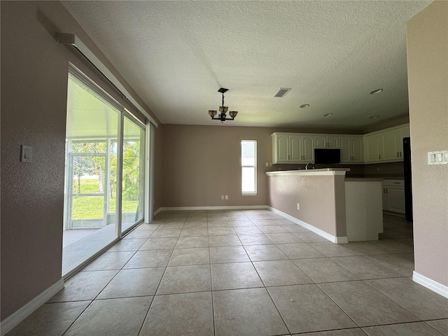 interior space with light tile patterned floors, a textured ceiling, and an inviting chandelier