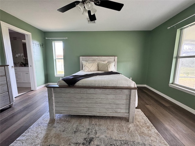 bedroom with connected bathroom, dark wood-type flooring, and ceiling fan