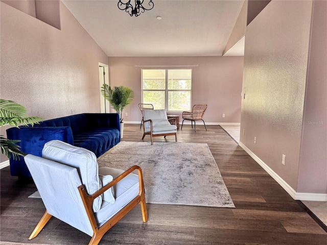 living room featuring lofted ceiling, a chandelier, and dark hardwood / wood-style flooring