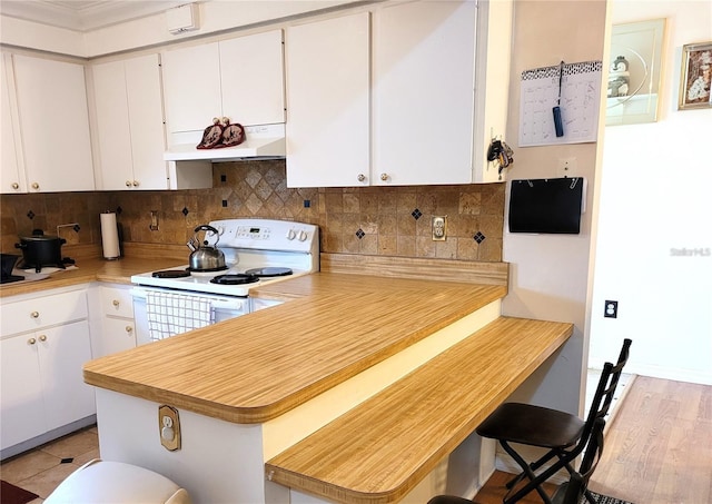 kitchen featuring white cabinetry, light hardwood / wood-style flooring, white range with electric cooktop, kitchen peninsula, and decorative backsplash