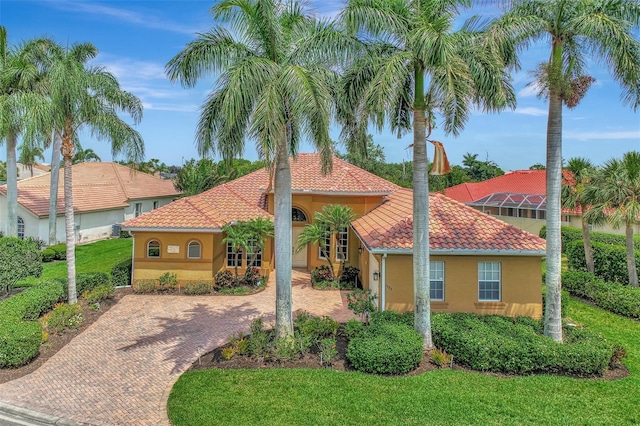 mediterranean / spanish-style home with stucco siding, a tiled roof, and a front yard