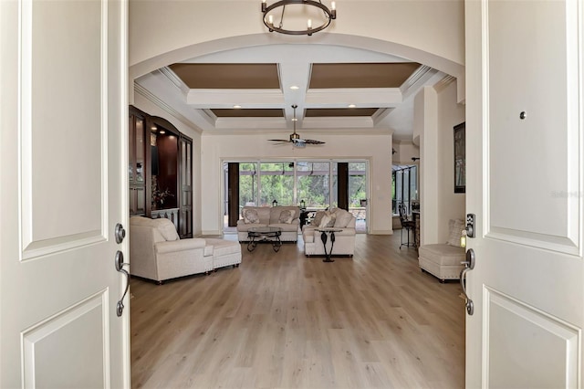 living room featuring coffered ceiling, ceiling fan with notable chandelier, crown molding, beam ceiling, and light hardwood / wood-style floors