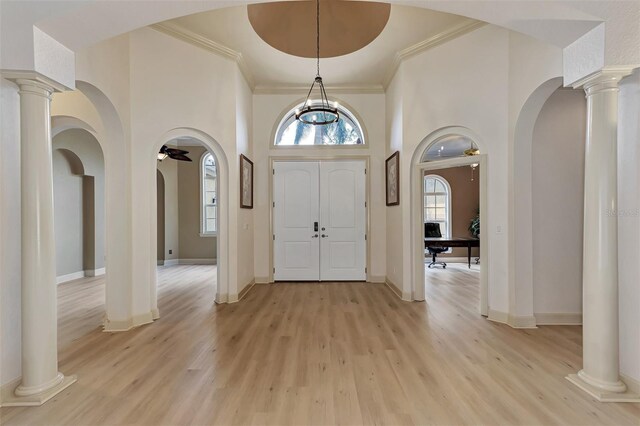 entrance foyer with light wood-type flooring, ornamental molding, decorative columns, and ceiling fan