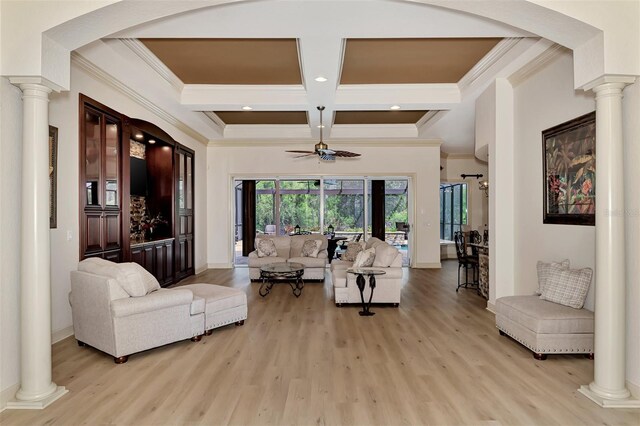 living room featuring light hardwood / wood-style flooring, ceiling fan, and ornate columns