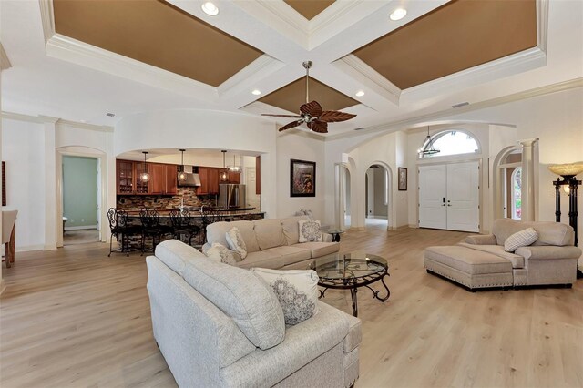 living room featuring coffered ceiling, ceiling fan, crown molding, and light hardwood / wood-style flooring