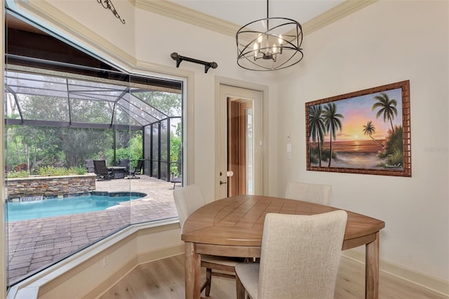 dining room with wood finished floors, a sunroom, baseboards, and ornamental molding