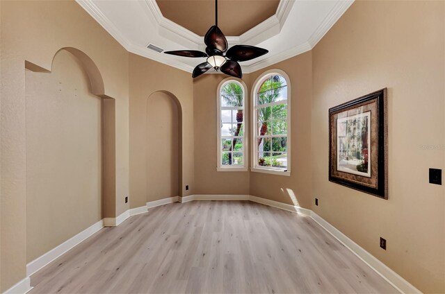 interior space featuring ornamental molding, a raised ceiling, light hardwood / wood-style flooring, and ceiling fan