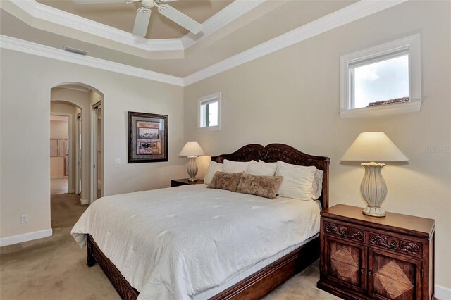 bedroom featuring crown molding, light colored carpet, ceiling fan, and a raised ceiling