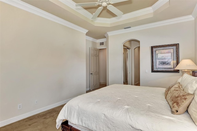 carpeted bedroom with ornamental molding, a raised ceiling, and ceiling fan