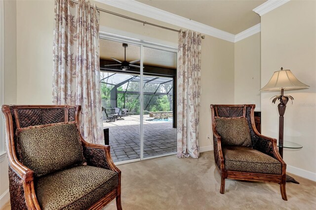 sitting room with ornamental molding, ceiling fan, and carpet