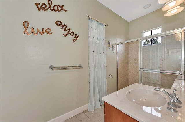 bathroom featuring tile patterned flooring, a shower with door, and vanity