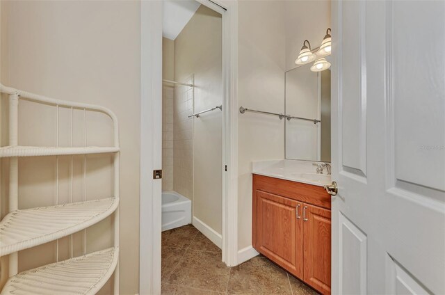 bathroom with tile patterned flooring, vanity, and tiled shower / bath