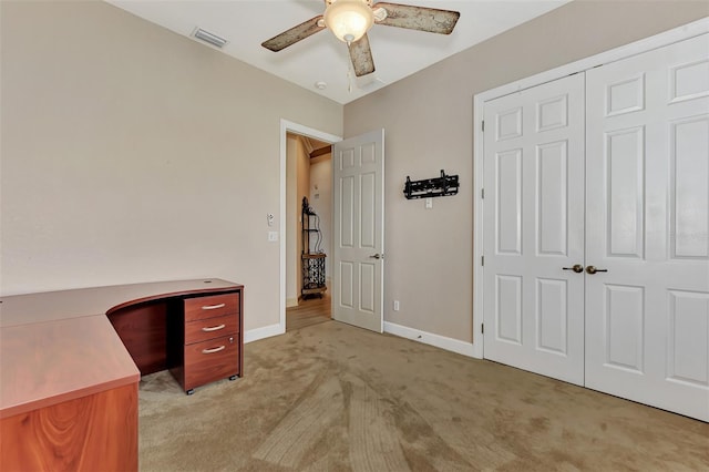 office space with a ceiling fan, visible vents, baseboards, and light carpet