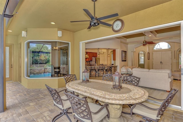 dining space with recessed lighting, stone finish flooring, crown molding, and ceiling fan with notable chandelier