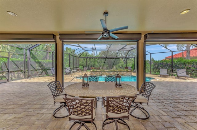 view of patio featuring a lanai, a ceiling fan, and an outdoor pool