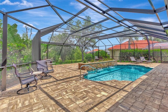 view of pool with pool water feature, a patio, and a lanai