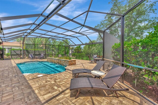 view of pool featuring glass enclosure, a patio area, and pool water feature