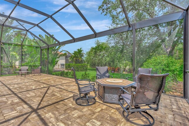 view of patio featuring glass enclosure and an outdoor fire pit