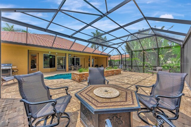 view of patio with an outdoor fire pit, grilling area, and a lanai