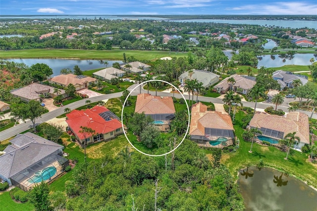 drone / aerial view featuring a residential view, view of golf course, and a water view