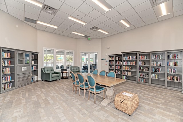 dining space featuring a drop ceiling, visible vents, carpet, and a high ceiling