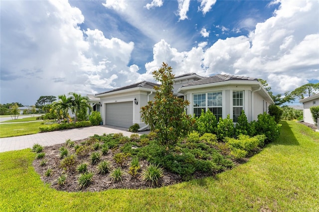 9982 Beachwalk Dr, Englewood, FL 34223 - view of front of property featuring driveway, a front yard, a garage, and stucco siding