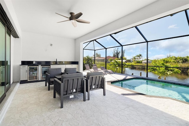 view of pool with ceiling fan and a water view