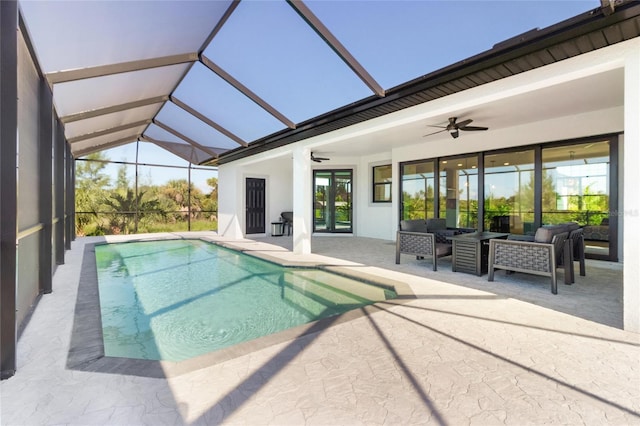 view of pool with an outdoor living space, glass enclosure, ceiling fan, and a patio area