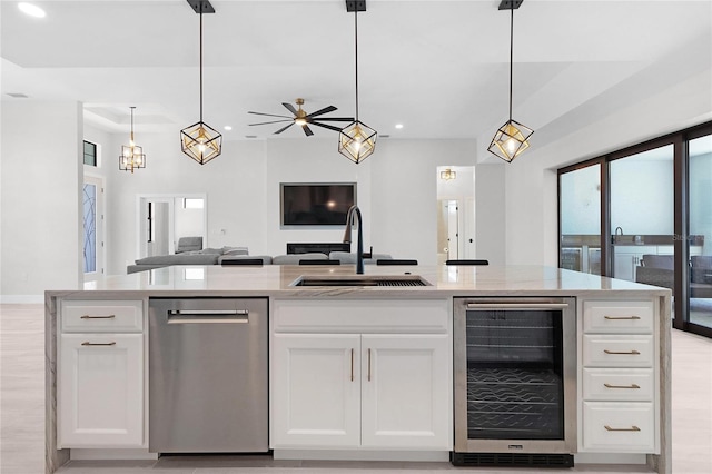 kitchen featuring pendant lighting, white cabinetry, wine cooler, and sink