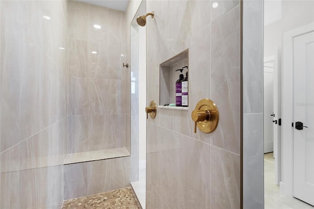 bathroom with tiled shower and tile walls