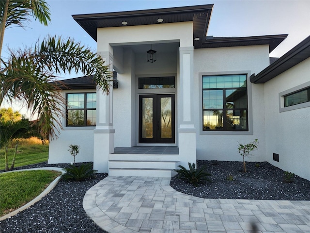 entrance to property with crawl space, french doors, and stucco siding