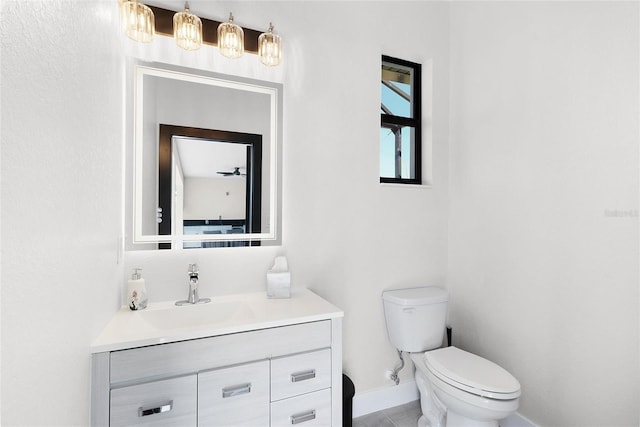 half bathroom featuring baseboards, vanity, and toilet