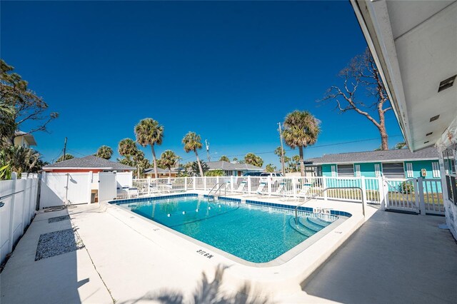 community pool with fence and a patio area