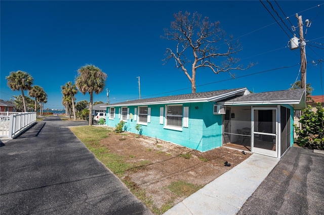 view of front of home featuring a sunroom and concrete block siding