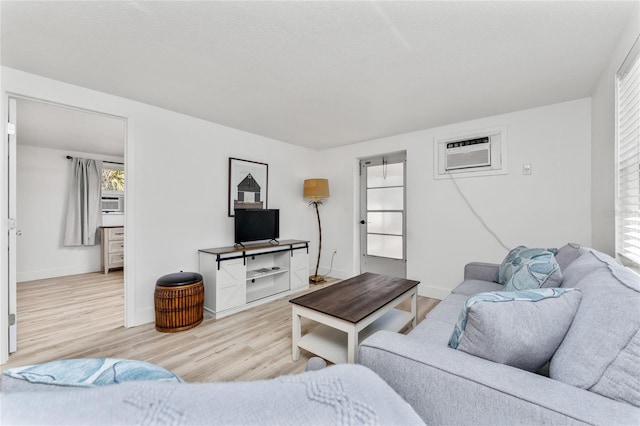 living area featuring a wall mounted AC, wood finished floors, and baseboards